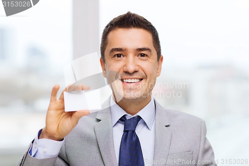 Image of smiling businessman in suit showing visiting card