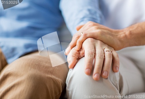 Image of close up of happy male gay couple holding hands