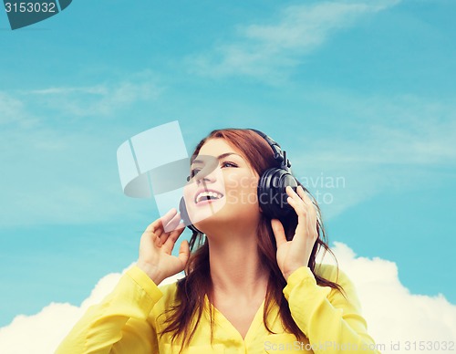 Image of smiling young girl in headphones at home