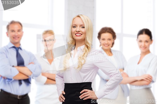 Image of smiling businesswoman over office team