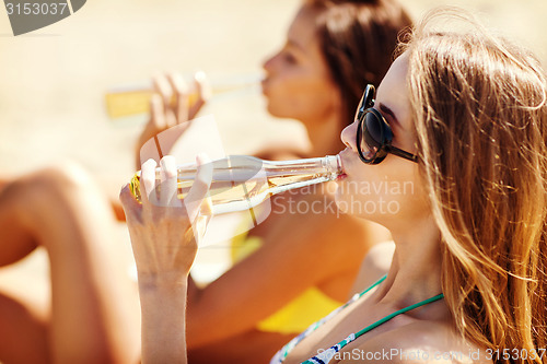 Image of girls with drinks on the beach chairs