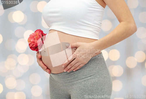 Image of close up of pregnant woman touching her bare tummy