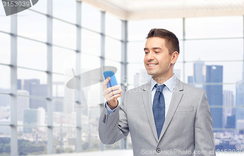 Image of happy businessman texting on smartphone