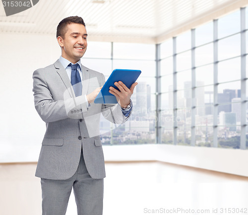 Image of happy businessman in suit holding tablet pc