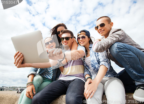Image of group of teenagers looking at tablet pc