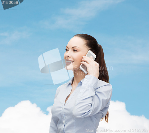 Image of young smiling businesswoman with smartphone