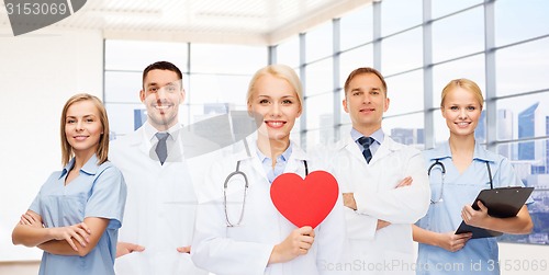 Image of happy young doctors cardiologists with red heart