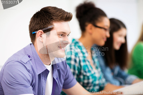 Image of student with computer studying at school