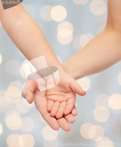 Image of close up of woman and little child hands together