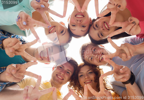 Image of group of smiling teenagers showing victory sign
