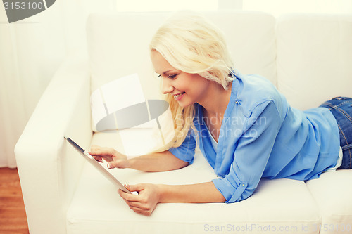 Image of smiling woman with tablet pc computer at home