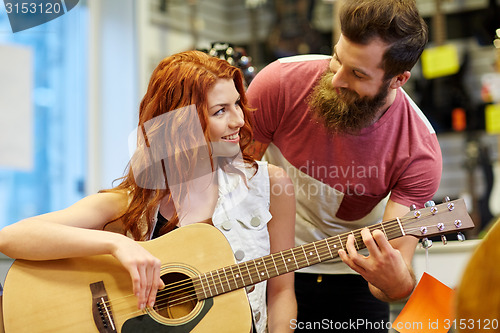 Image of couple of musicians with guitar at music store