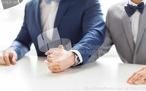 Image of close up of happy male gay couple holding hands