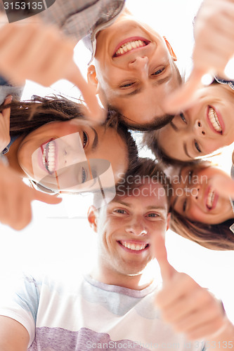 Image of group of smiling teenagers looking down