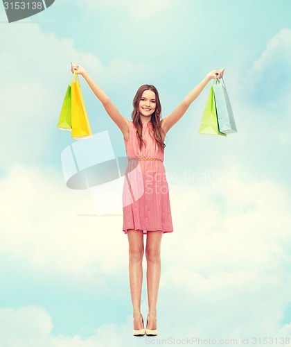 Image of smiling woman in dress with many shopping bags