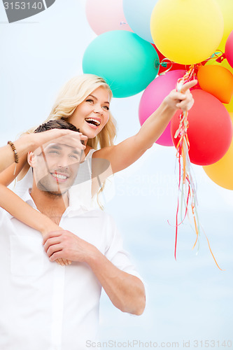 Image of couple with colorful balloons at seaside