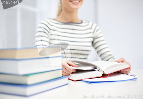 Image of close up of young woman reading book at school