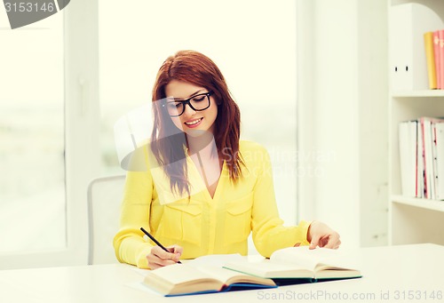 Image of smiling student girl reading books in library