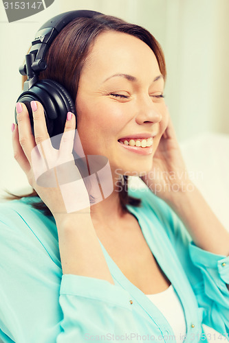 Image of smiling woman with headphones at home