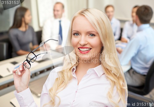 Image of smiling businesswoman or secretary in office