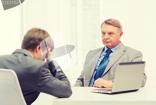 Image of older man and young man having argument in office