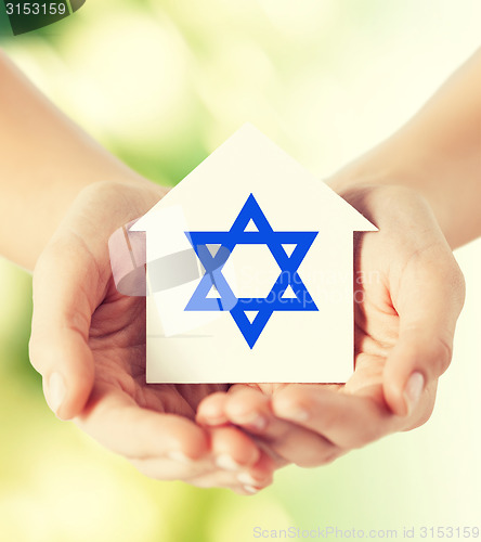Image of close up of hands holding house with star of david
