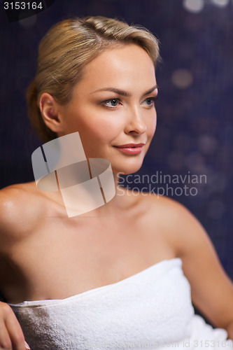 Image of beautiful young woman sitting in bath towel