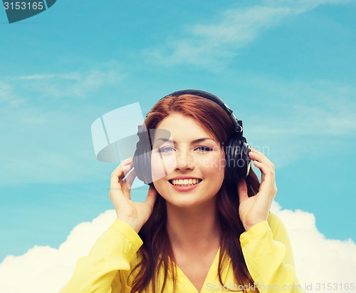 Image of smiling young girl in headphones at home