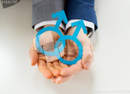 Image of close up of happy male gay couple with love symbol