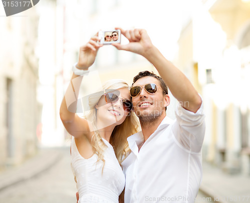 Image of travelling couple taking photo picture with camera