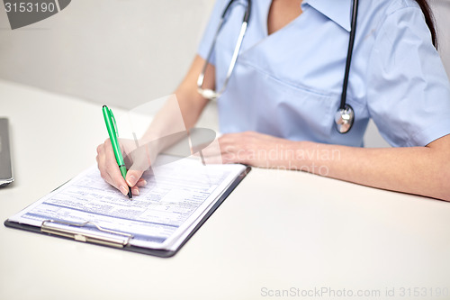 Image of close up of female doctor writing prescription