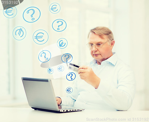 Image of old man with laptop and credit card at home