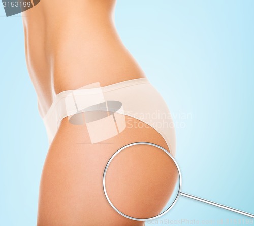 Image of close up of woman buttocks and magnifier