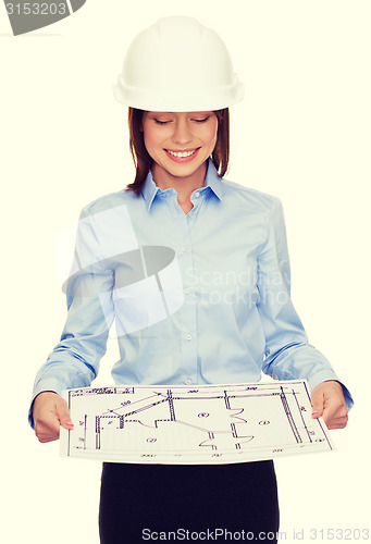 Image of businesswoman in helmet looking at blueprint