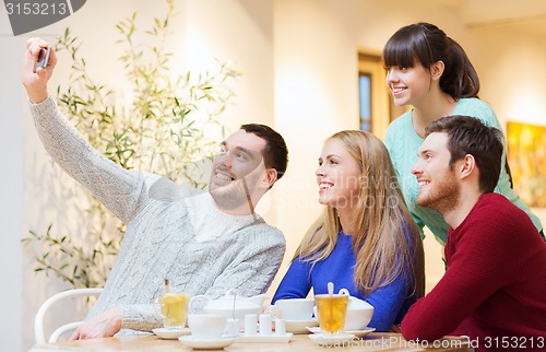 Image of group of friends taking selfie with smartphone