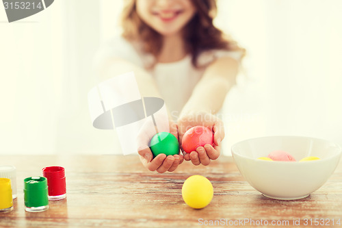 Image of close up of girl holding colored eggs