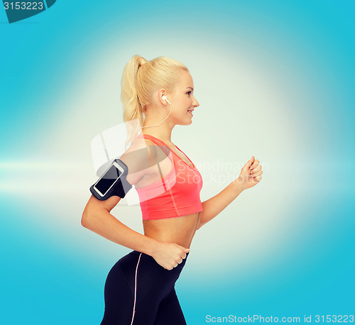 Image of sporty woman running with smartphone and earphones