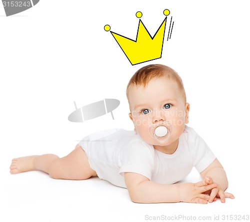 Image of smiling baby lying on floor with dummy in mouth