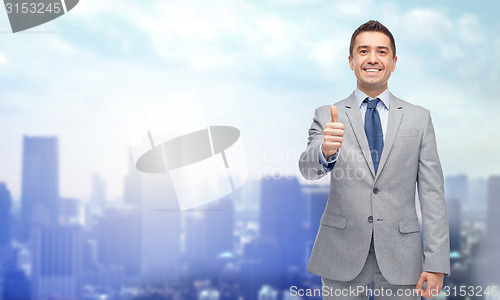 Image of happy businessman in suit showing thumbs up