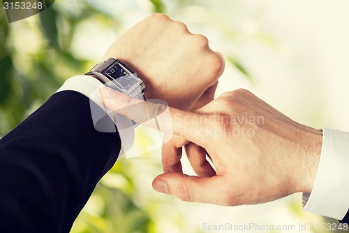 Image of man looking at wristwatch