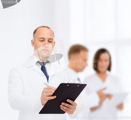 Image of serious male doctor with clipboard