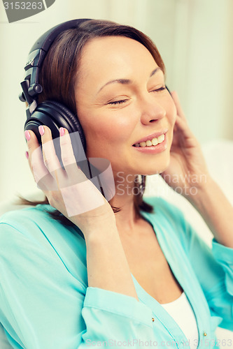 Image of smiling woman with headphones at home
