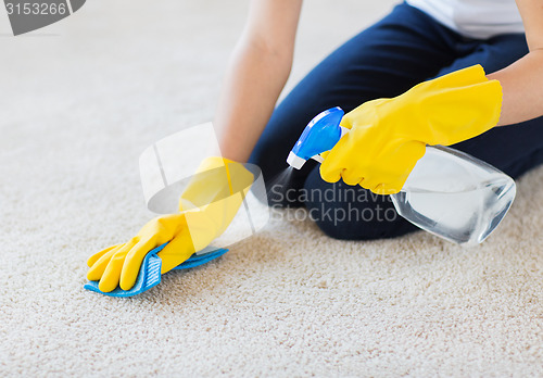 Image of close up of woman with cloth cleaning carpet