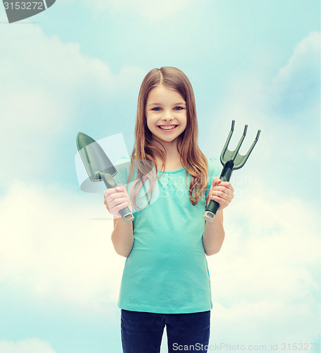 Image of smiling little girl with rake and scoop