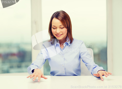 Image of smiling woman pointing to something imaginary