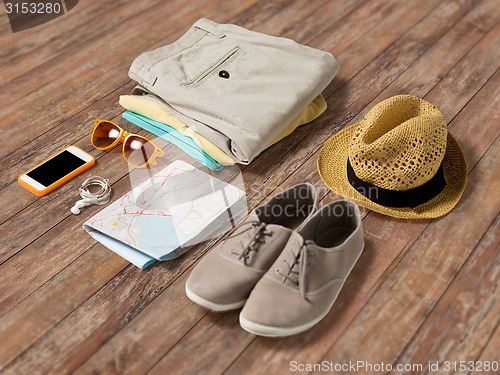 Image of close up of summer clothes and travel map on table