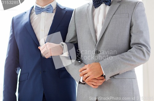 Image of close up of happy male gay couple holding hands