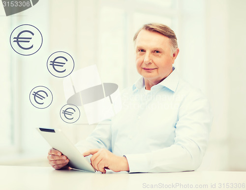 Image of old man with tablet computer at home