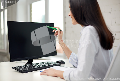 Image of close up of woman with computer monitor in office