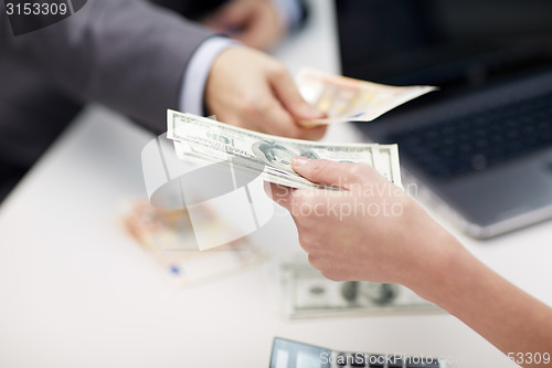 Image of close up of hands giving or exchanging money